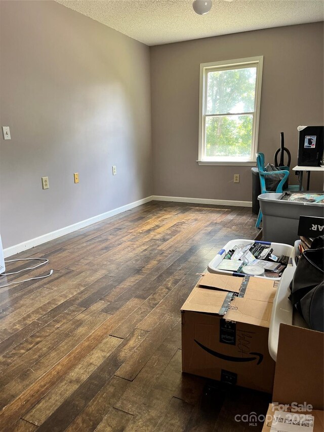 office area featuring baseboards, dark wood finished floors, and a textured ceiling