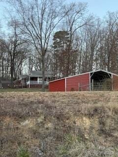 view of yard featuring a detached carport, a pole building, and an outdoor structure