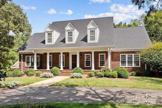 cape cod-style house with covered porch and a front yard