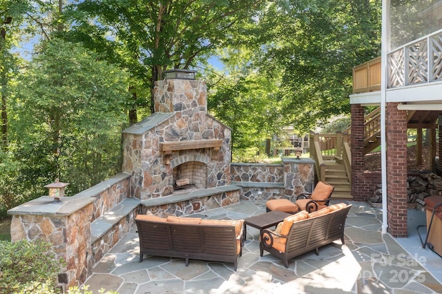 view of patio with a balcony and an outdoor living space with a fireplace