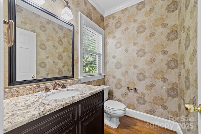 bathroom with hardwood / wood-style floors, toilet, vanity, and crown molding