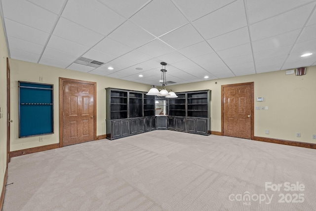 empty room featuring carpet and a drop ceiling