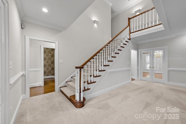 stairway with baseboards, crown molding, french doors, carpet floors, and recessed lighting