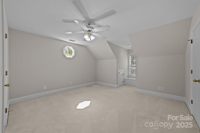 additional living space featuring visible vents, vaulted ceiling, light carpet, and baseboards