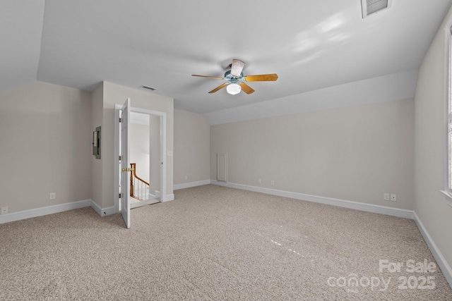 additional living space featuring lofted ceiling, baseboards, light carpet, and visible vents