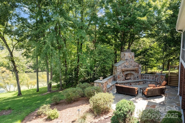 view of yard featuring an outdoor living space with a fireplace and a patio