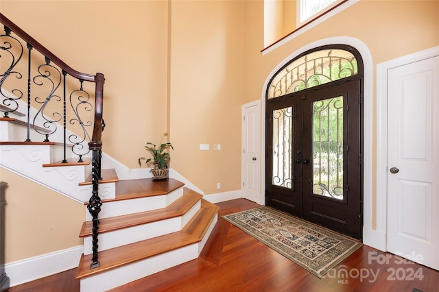 entryway with french doors, a healthy amount of sunlight, dark hardwood / wood-style floors, and a high ceiling