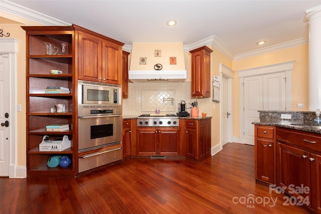 kitchen featuring dark hardwood / wood-style flooring, ornamental molding, dark stone counters, and appliances with stainless steel finishes