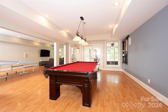 playroom with french doors, pool table, a tray ceiling, and light hardwood / wood-style floors