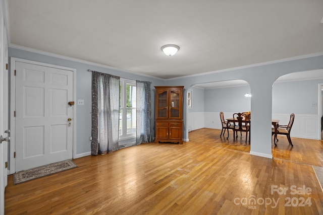 entrance foyer featuring ornamental molding and light wood-type flooring