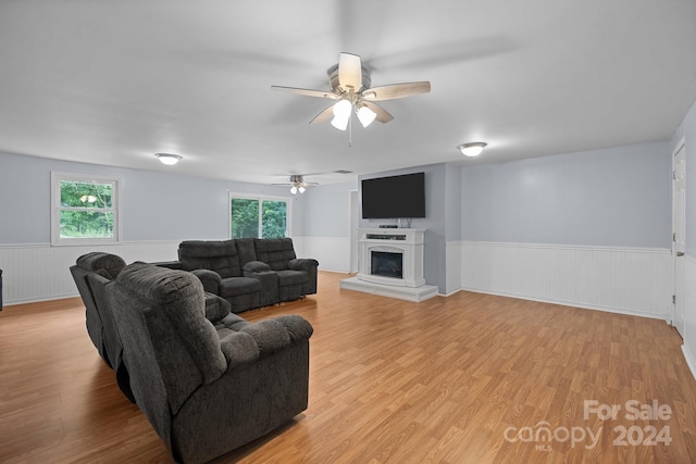 living room featuring a healthy amount of sunlight, ceiling fan, and light wood-type flooring