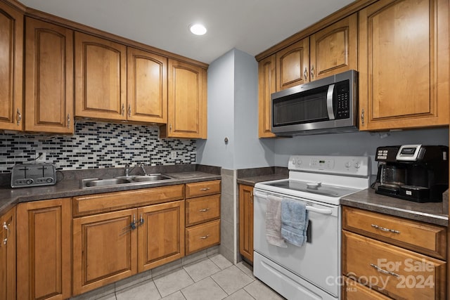 kitchen featuring white range with electric stovetop, sink, light tile patterned floors, and decorative backsplash