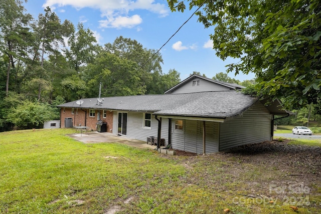 back of house featuring a lawn and a patio