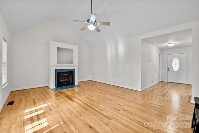 unfurnished living room featuring plenty of natural light, lofted ceiling, ceiling fan, and light hardwood / wood-style flooring