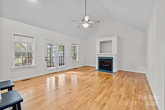 unfurnished living room featuring ceiling fan, high vaulted ceiling, and light wood-type flooring