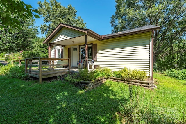 view of front of house featuring a front lawn and a wooden deck