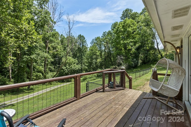 wooden terrace featuring a lawn