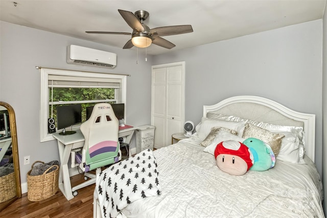 bedroom with a wall unit AC, wood-type flooring, a closet, and ceiling fan