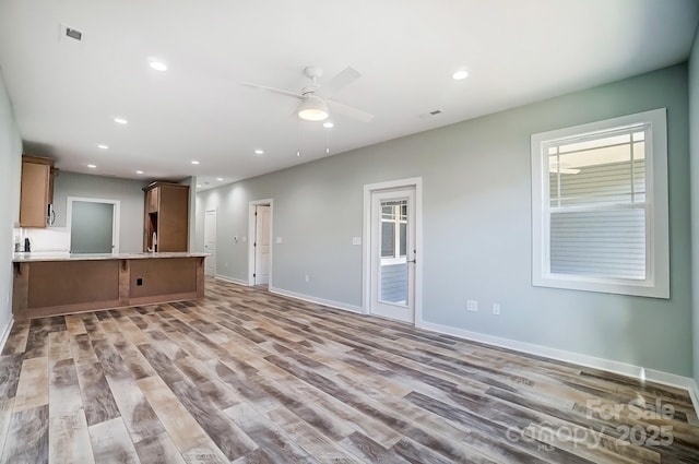 unfurnished living room featuring ceiling fan and light hardwood / wood-style floors