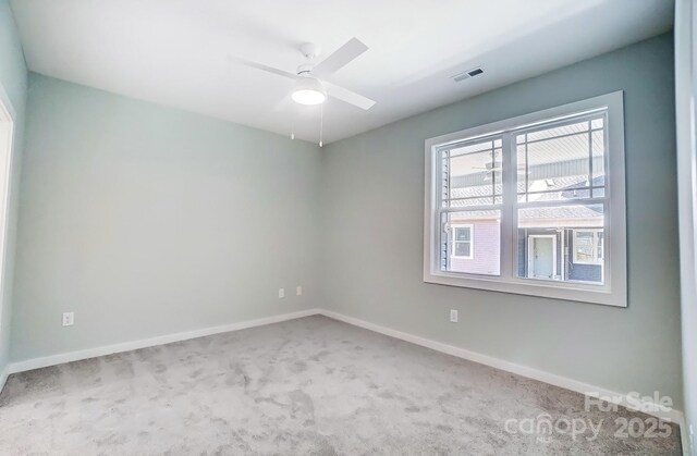 carpeted spare room featuring ceiling fan