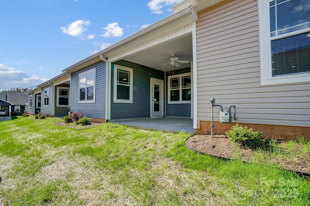 property entrance featuring ceiling fan, a patio, and a yard