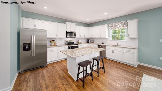 kitchen with white cabinetry, sink, a kitchen island, and appliances with stainless steel finishes