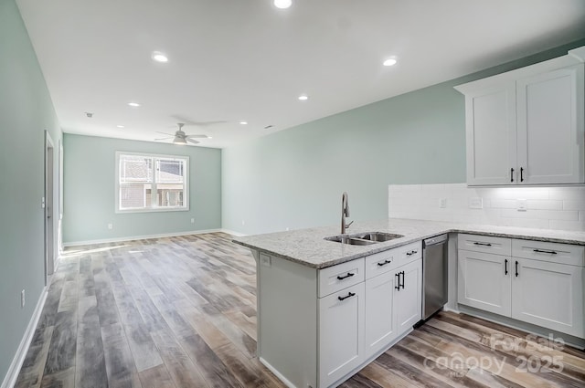 kitchen featuring sink, kitchen peninsula, white cabinets, and light hardwood / wood-style floors