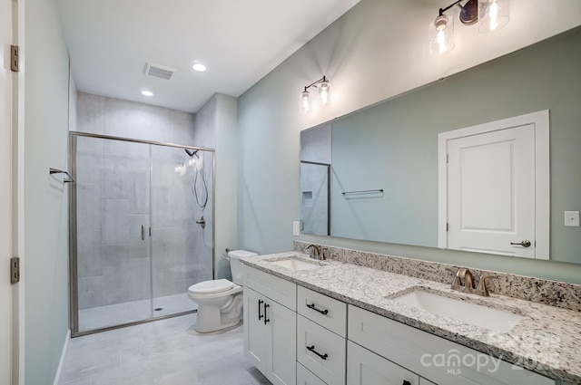 bathroom with a shower with shower door, toilet, and vanity