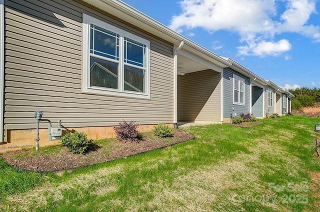 view of side of home with a yard