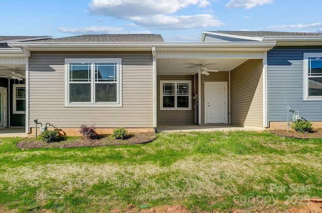 property entrance featuring ceiling fan and a lawn