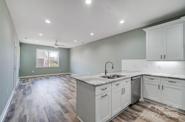 kitchen featuring white cabinets, kitchen peninsula, and sink