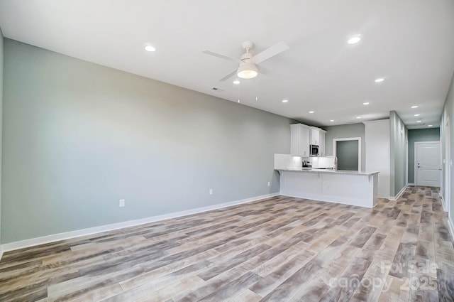 unfurnished living room with ceiling fan and light hardwood / wood-style floors