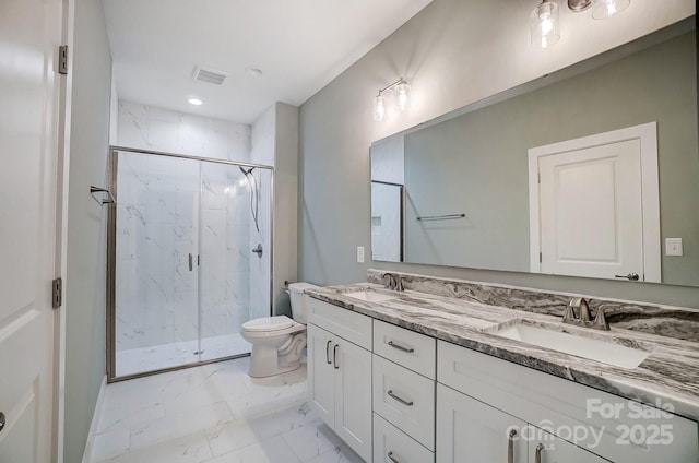 bathroom featuring vanity, a shower with shower door, and toilet