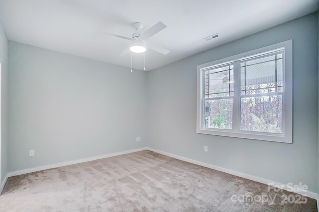 carpeted empty room with ceiling fan and a wealth of natural light