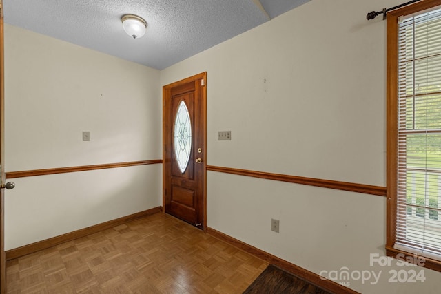 entryway featuring baseboards and a textured ceiling