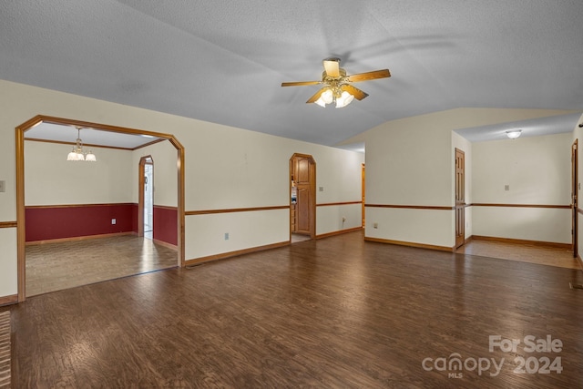 empty room featuring dark wood-style floors, arched walkways, vaulted ceiling, a textured ceiling, and ceiling fan with notable chandelier