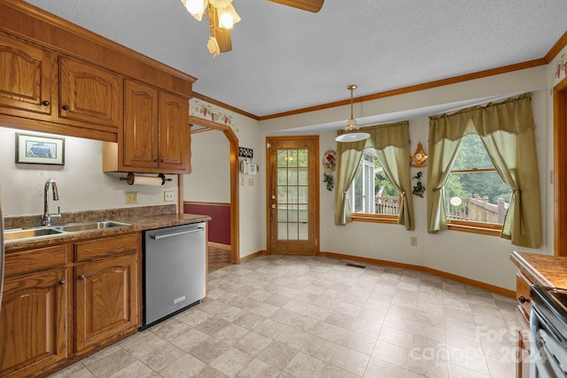 kitchen featuring appliances with stainless steel finishes, brown cabinetry, a sink, and hanging light fixtures