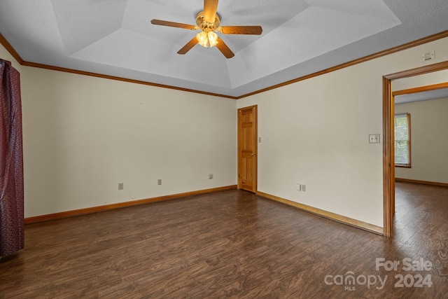 spare room featuring baseboards, a tray ceiling, dark wood-style flooring, and ornamental molding