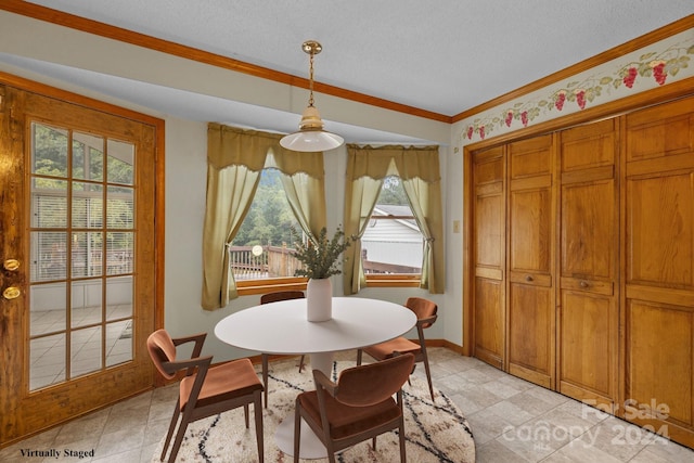 dining space featuring ornamental molding, a textured ceiling, and baseboards