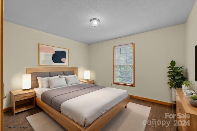 bedroom with dark wood-style floors and baseboards