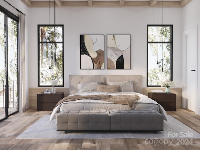 bedroom with light hardwood / wood-style floors, beam ceiling, and access to exterior