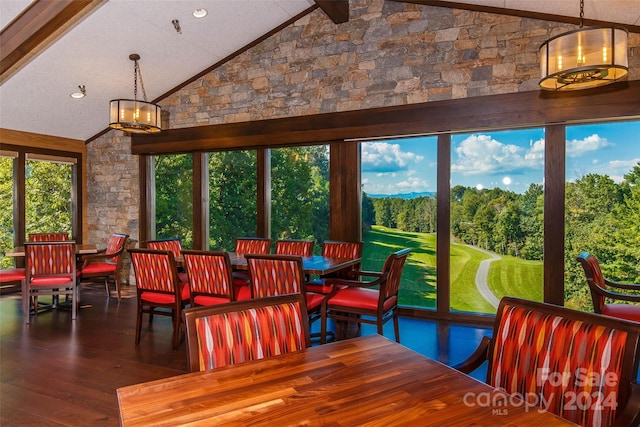 dining area featuring wood-type flooring and high vaulted ceiling