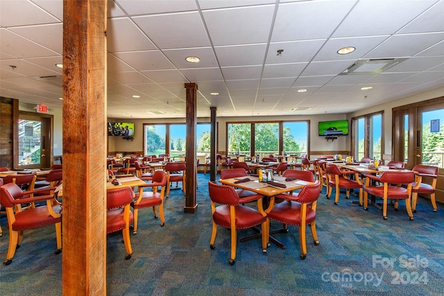 dining room featuring a drop ceiling and carpet flooring