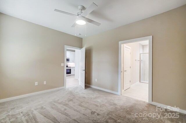 empty room with ceiling fan and light carpet