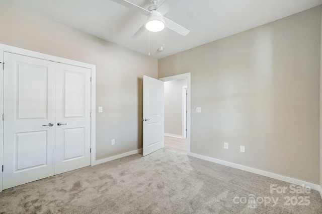 unfurnished bedroom with ceiling fan, a closet, and light carpet