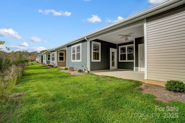 exterior space with ceiling fan, a yard, and a patio