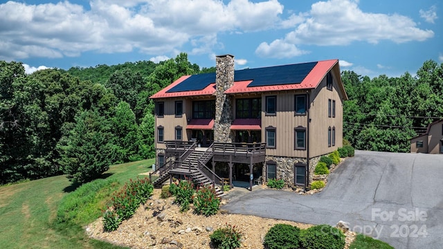 view of front of property featuring solar panels and a front lawn