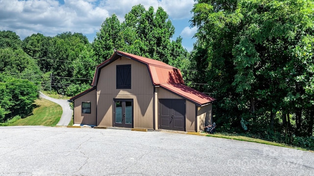 view of front of house with french doors and an outbuilding