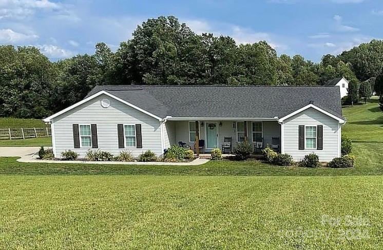 view of front of house with covered porch and a front lawn