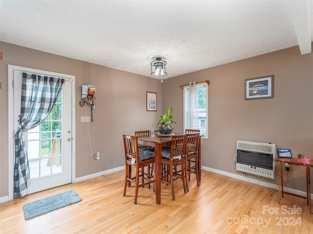 dining room with a healthy amount of sunlight, light hardwood / wood-style floors, and heating unit